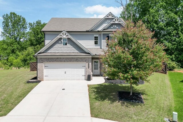 craftsman-style home featuring brick siding, driveway, a front yard, and a garage