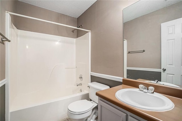 bathroom with a textured ceiling, shower / bathtub combination, vanity, and toilet