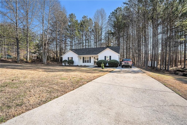 view of front of property featuring a front yard and concrete driveway