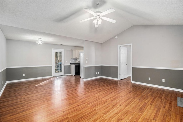 unfurnished living room featuring baseboards, vaulted ceiling, and wood finished floors