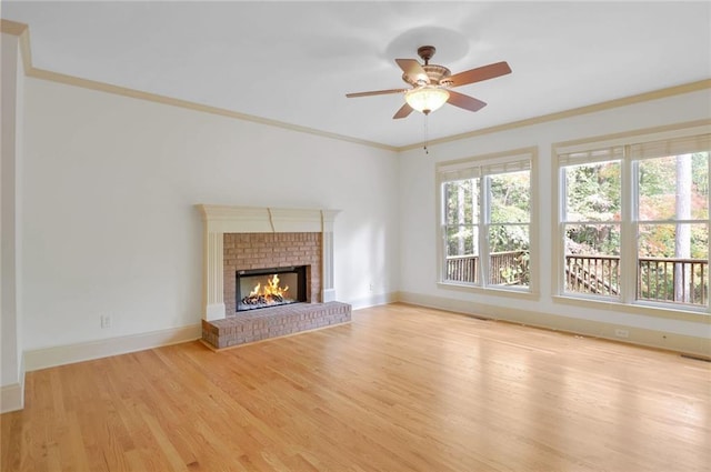 unfurnished living room with ceiling fan, light hardwood / wood-style floors, crown molding, and a fireplace