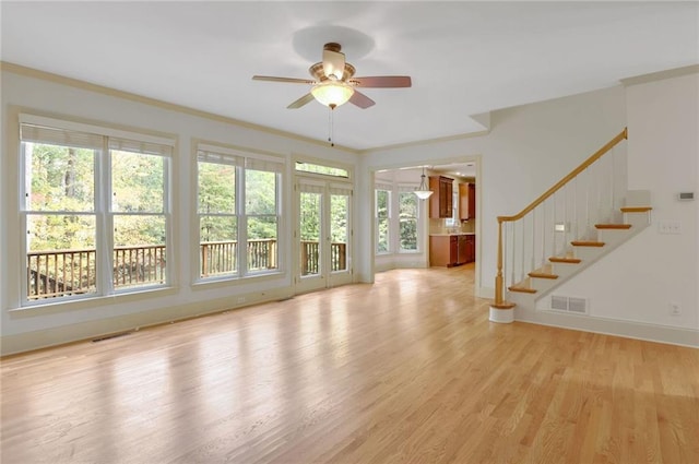 unfurnished living room featuring ceiling fan, light wood-type flooring, and crown molding