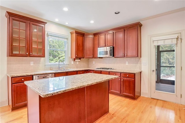 kitchen featuring light hardwood / wood-style floors, a center island, stainless steel appliances, and sink