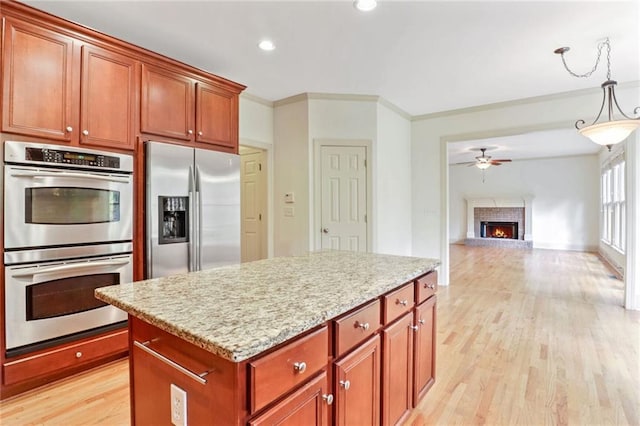 kitchen with crown molding, light hardwood / wood-style flooring, ceiling fan, appliances with stainless steel finishes, and decorative light fixtures