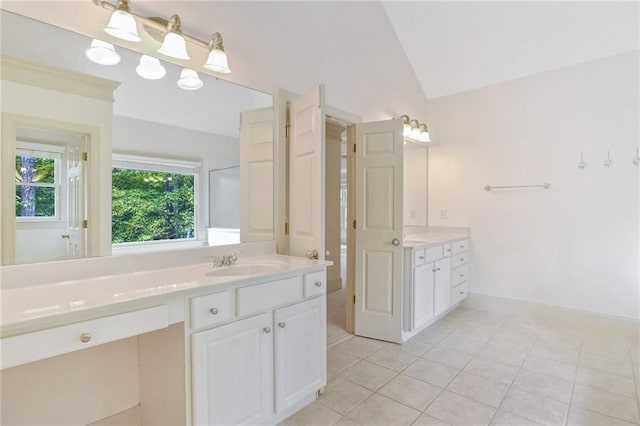 bathroom with tile patterned flooring, vanity, and lofted ceiling