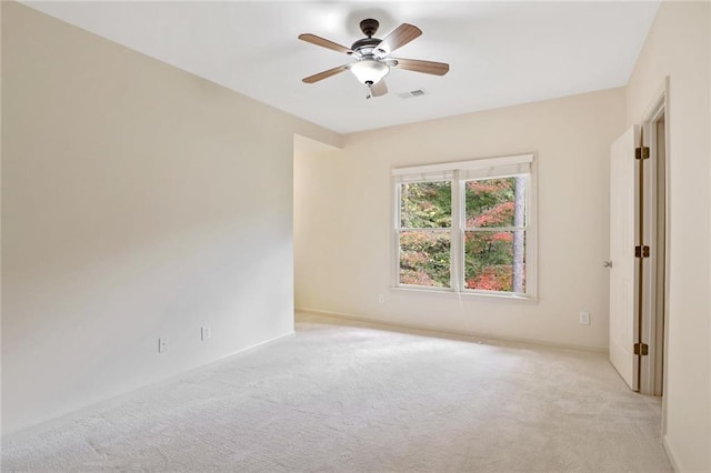 carpeted spare room featuring ceiling fan