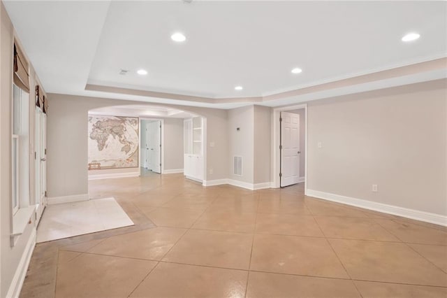 tiled empty room with a raised ceiling