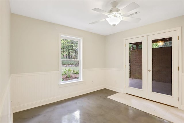 spare room featuring ceiling fan, concrete flooring, and french doors