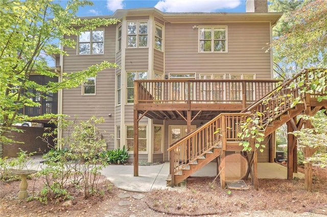 rear view of property featuring a deck and a patio area