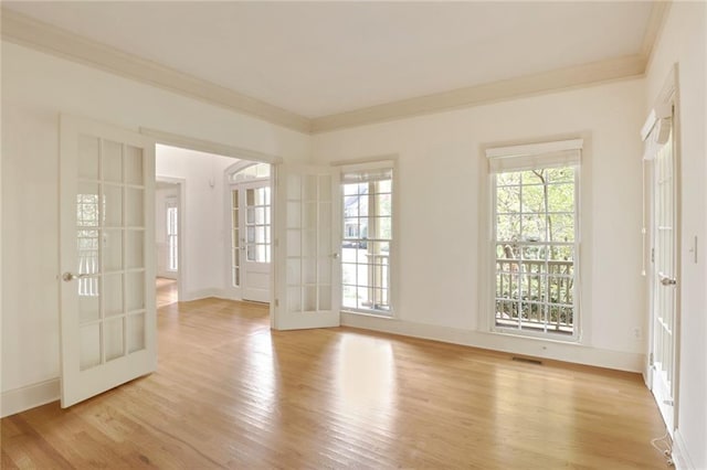 spare room featuring light wood-type flooring, crown molding, and french doors