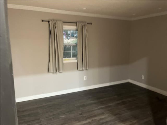 spare room with dark wood-type flooring and ornamental molding