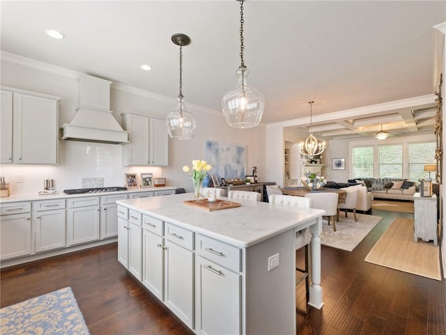 2506 Skyland Dr NE Unit 17, Atlanta, GA 30319 - kitchen featuring a breakfast bar area, premium range hood, a kitchen island, stainless steel gas cooktop, and ornamental molding