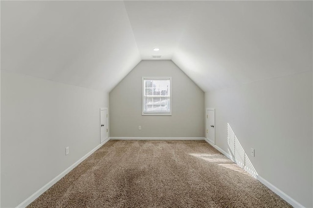 bonus room featuring light carpet, vaulted ceiling, and baseboards