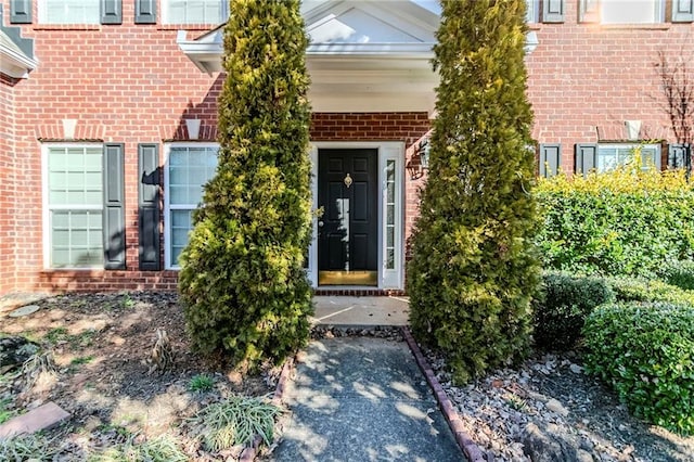 doorway to property featuring brick siding