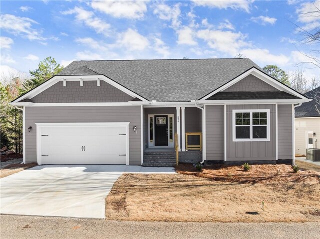 view of front of house with cooling unit, a garage, and a front lawn