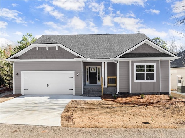 view of front of house featuring a garage, central air condition unit, and concrete driveway