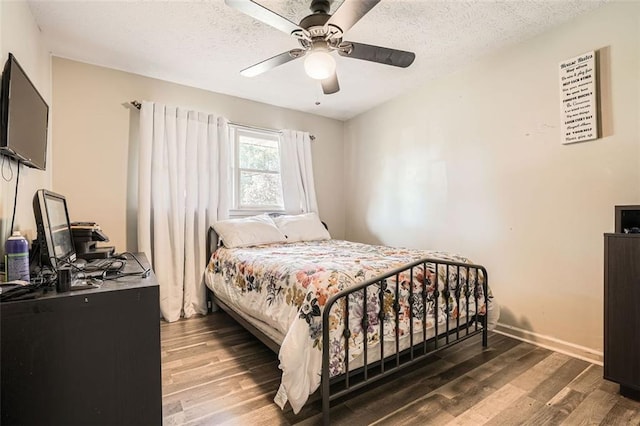 bedroom featuring ceiling fan, dark hardwood / wood-style floors, and a textured ceiling