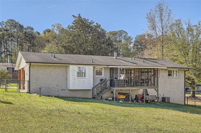 rear view of property with a yard, central AC, and a sunroom