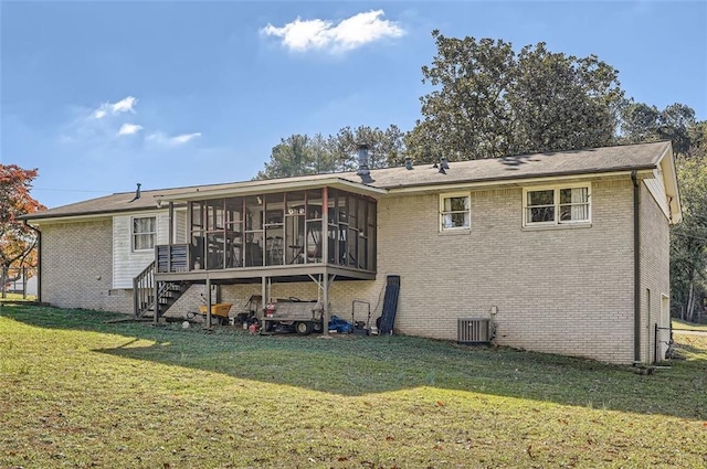 back of house featuring central air condition unit, a sunroom, and a yard