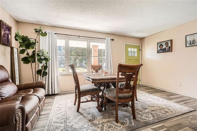 dining space with hardwood / wood-style floors and a textured ceiling