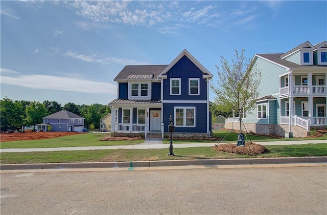 view of front of home featuring metal roof, board and batten siding, a front lawn, and a standing seam roof