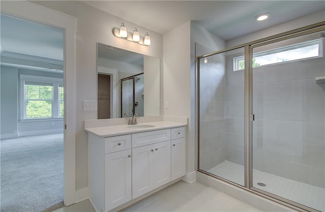 bathroom with vanity, a shower stall, and baseboards