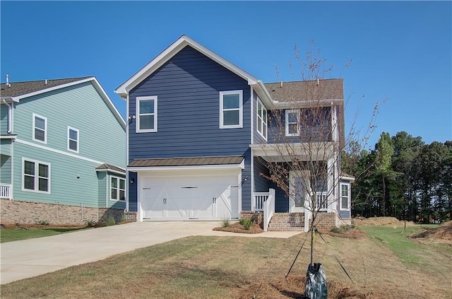 traditional home featuring a front lawn, a balcony, an attached garage, and driveway