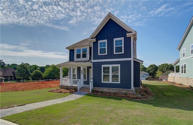 view of front of house featuring a porch, board and batten siding, a standing seam roof, and a front yard