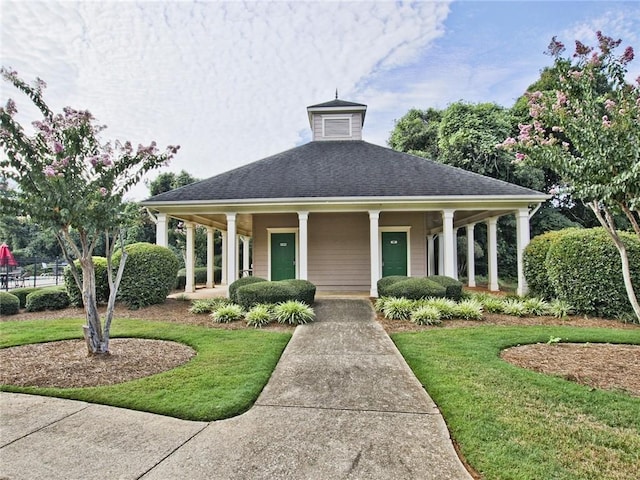 view of front facade featuring a front lawn, a porch, and a shingled roof