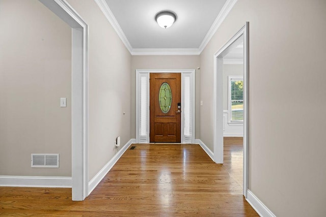 entrance foyer featuring ornamental molding and light hardwood / wood-style flooring