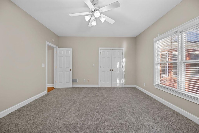 carpeted spare room featuring ceiling fan