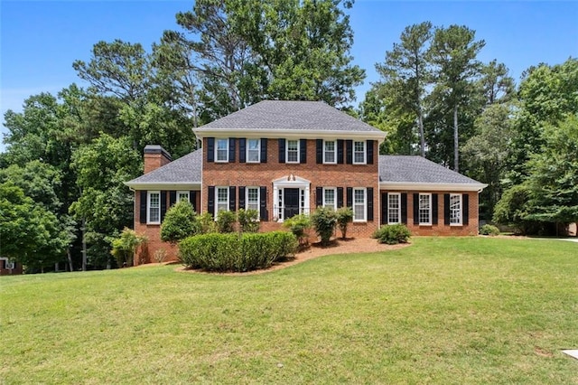 4546 Graywood Trce, Peachtree Corners, GA 30092 - colonial-style house featuring brick siding, a front lawn, a chimney, and roof with shingles