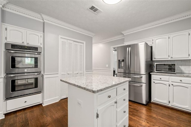 4546 Graywood Trce, Peachtree Corners, GA 30092 - kitchen with stainless steel appliances, ornamental molding, dark wood-type flooring, white cabinetry, and a kitchen island