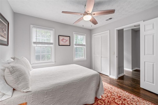 4546 Graywood Trce, Peachtree Corners, GA 30092 - bedroom with wood finished floors, multiple windows, a closet, a ceiling fan, and a textured ceiling