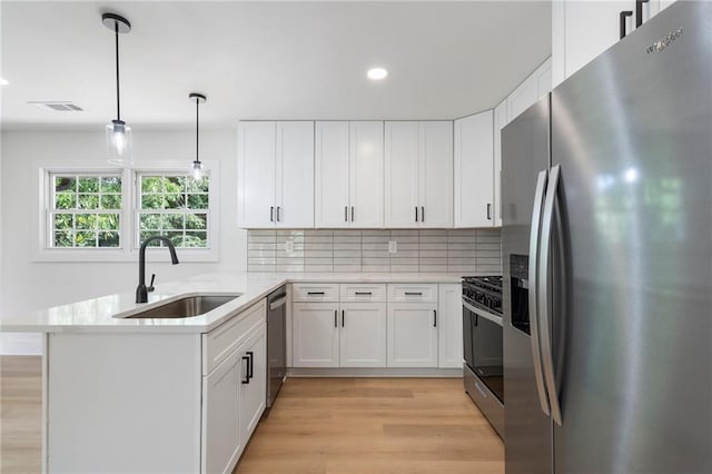 1409 Georgia Ave, East Point, GA 30344 - kitchen featuring appliances with stainless steel finishes, light wood-style flooring, a peninsula, tasteful backsplash, and recessed lighting