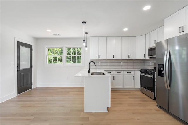 1409 Georgia Ave, East Point, GA 30344 - kitchen with appliances with stainless steel finishes, a peninsula, white cabinetry, light countertops, and recessed lighting