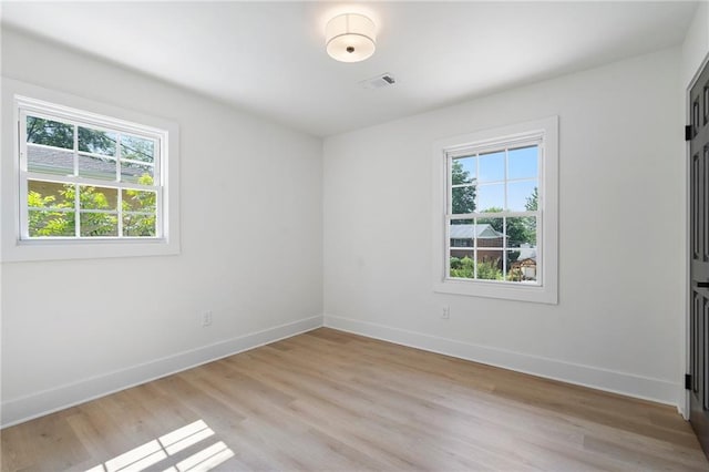 1409 Georgia Ave, East Point, GA 30344 - unfurnished bedroom featuring multiple windows and light wood-type flooring
