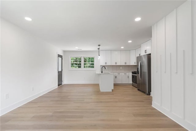 1409 Georgia Ave, East Point, GA 30344 - kitchen with appliances with stainless steel finishes, light countertops, white cabinetry, open floor plan, and recessed lighting
