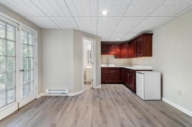 940 Waters Reach Ct, Alpharetta, GA 30022 - kitchen with light countertops, fridge, a baseboard heating unit, a sink, and light wood finished floors