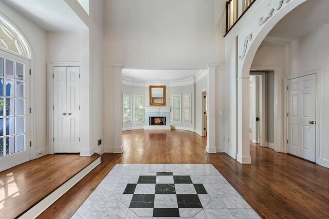 940 Waters Reach Ct, Alpharetta, GA 30022 - foyer entrance featuring baseboards, a lit fireplace, a towering ceiling, and wood finished floors