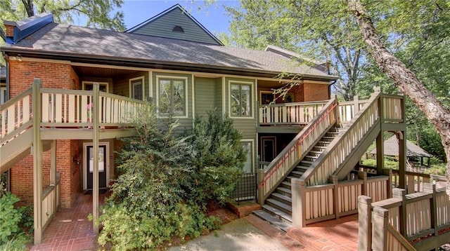 470 Ansley Walk Ter NE, Atlanta, GA 30309 - rear view of property with brick siding, stairs, a shingled roof, and a wooden deck
