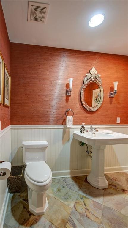 470 Ansley Walk Ter NE, Atlanta, GA 30309 - half bath featuring a wainscoted wall and wallpapered walls