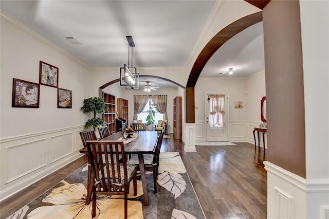2837 Peachstone Ct, Lawrenceville, GA 30043 - dining space with wood finished floors, arched walkways, a decorative wall, crown molding, and a wainscoted wall