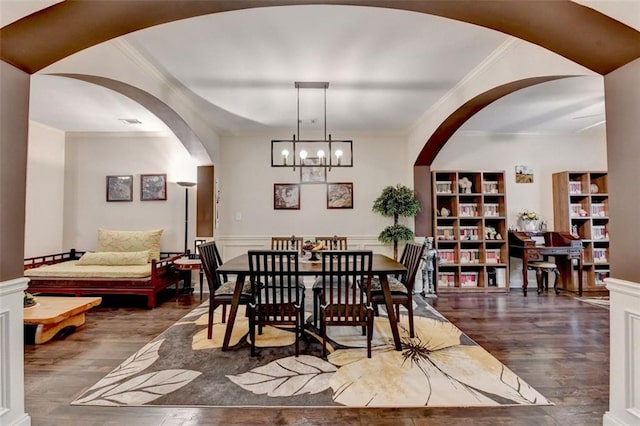 2837 Peachstone Ct, Lawrenceville, GA 30043 - dining area featuring crown molding, wood finished floors, arched walkways, and a chandelier