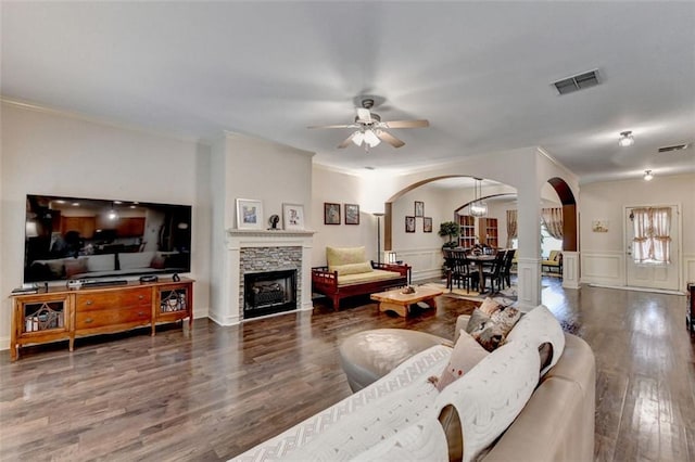 2837 Peachstone Ct, Lawrenceville, GA 30043 - living room featuring arched walkways, a ceiling fan, crown molding, wood finished floors, and a stone fireplace