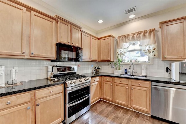 2837 Peachstone Ct, Lawrenceville, GA 30043 - kitchen with stainless steel appliances, a sink, light brown cabinets, light wood-style floors, and dark stone countertops