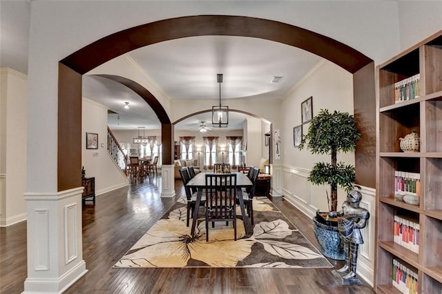 2837 Peachstone Ct, Lawrenceville, GA 30043 - dining area featuring arched walkways, wood finished floors, crown molding, a chandelier, and a wainscoted wall