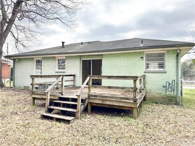 back of house featuring brick siding and a wooden deck