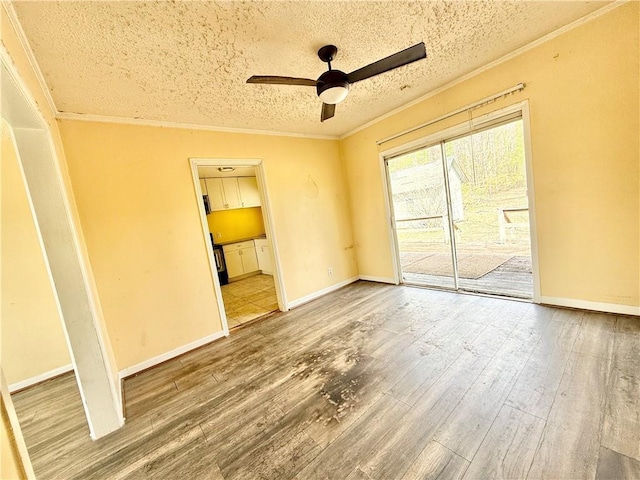 empty room featuring a textured ceiling, crown molding, and wood finished floors