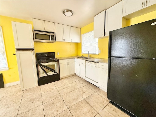 kitchen featuring freestanding refrigerator, a sink, range with electric stovetop, dishwasher, and stainless steel microwave